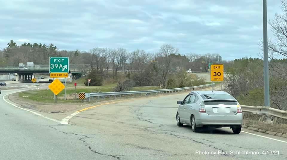 Image of gore sign for MA 30 exit with new milepost based exit number and yellow Old Exit 24 sign attached below on ramp from I-95/128 North in Newton, by Paul Schlichtman, April 2021