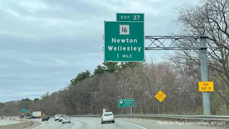Image of 1 mile advance overhead sign for MA 16 exit with new milepost based exit number and yellow Old Exit 21 sign on support on I-95/MA 128 North in Wellesley, by Paul Schlichtman, April 2021