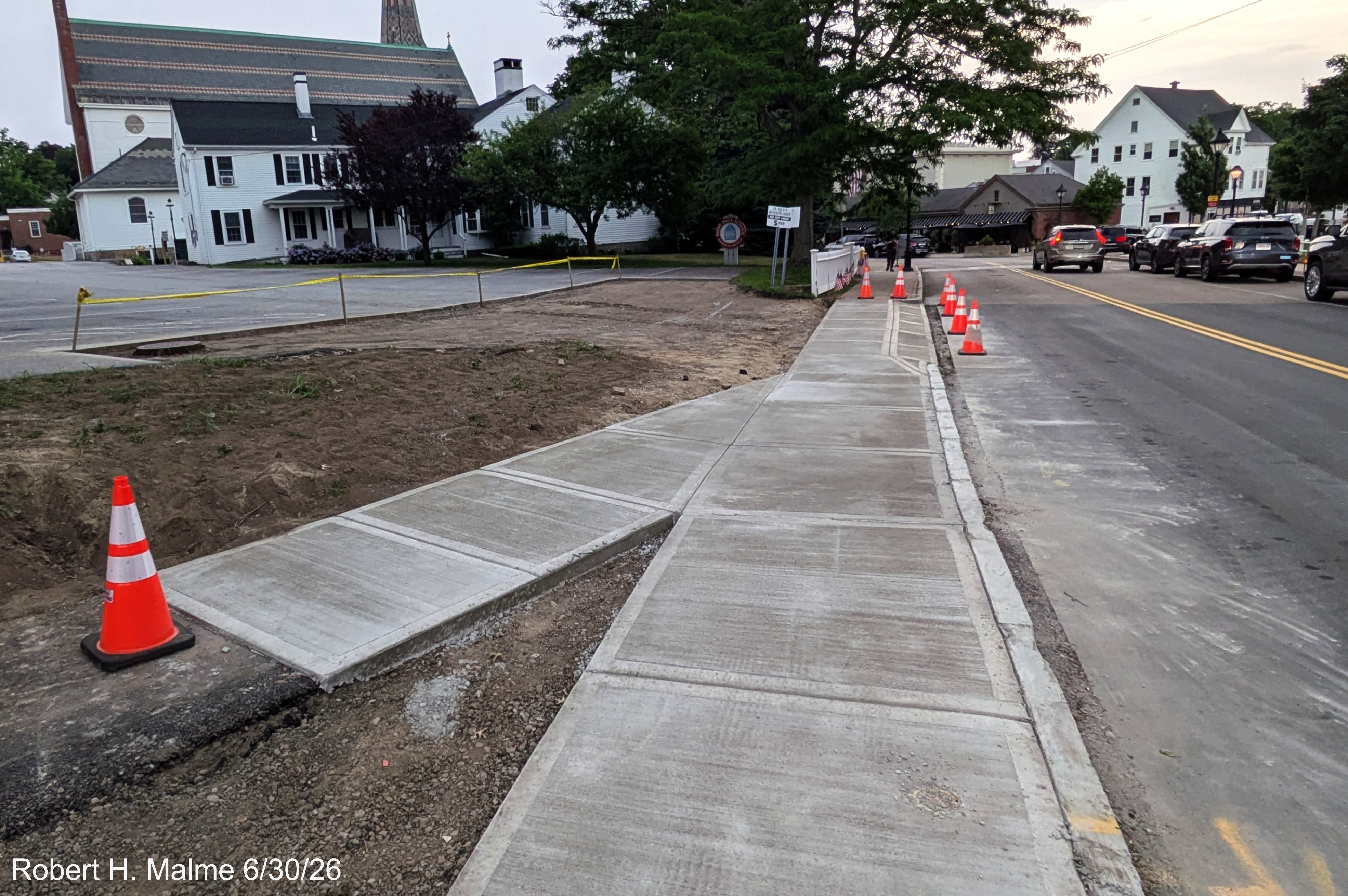 Image taken looking along North Street at the newly installed concrete sidewalk along
	the road, June 2026