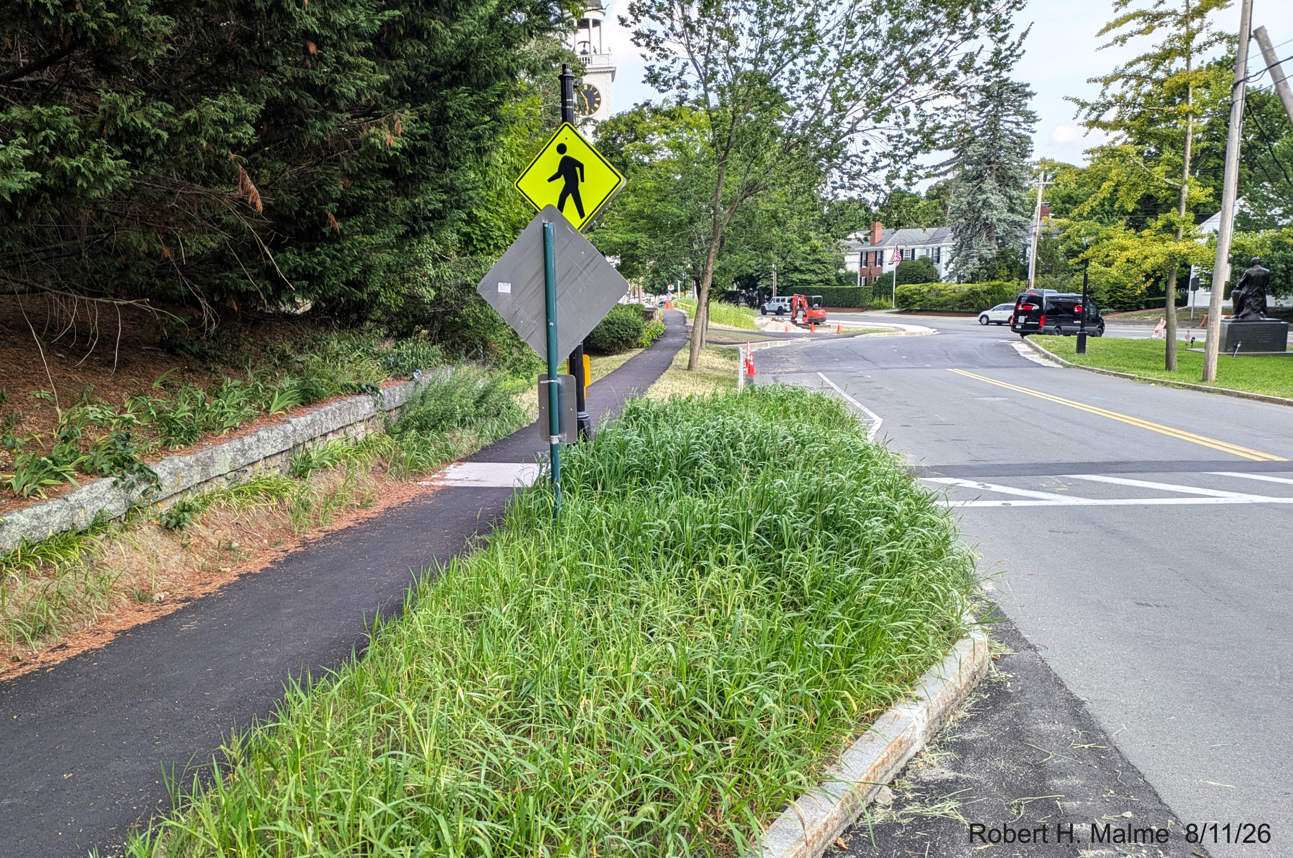 Image taken looking along Lincoln Street at pedestrian crossing with overgrown grasses
	now surrounding sidewalk across from the Benjamin Lincoln House, August 2026