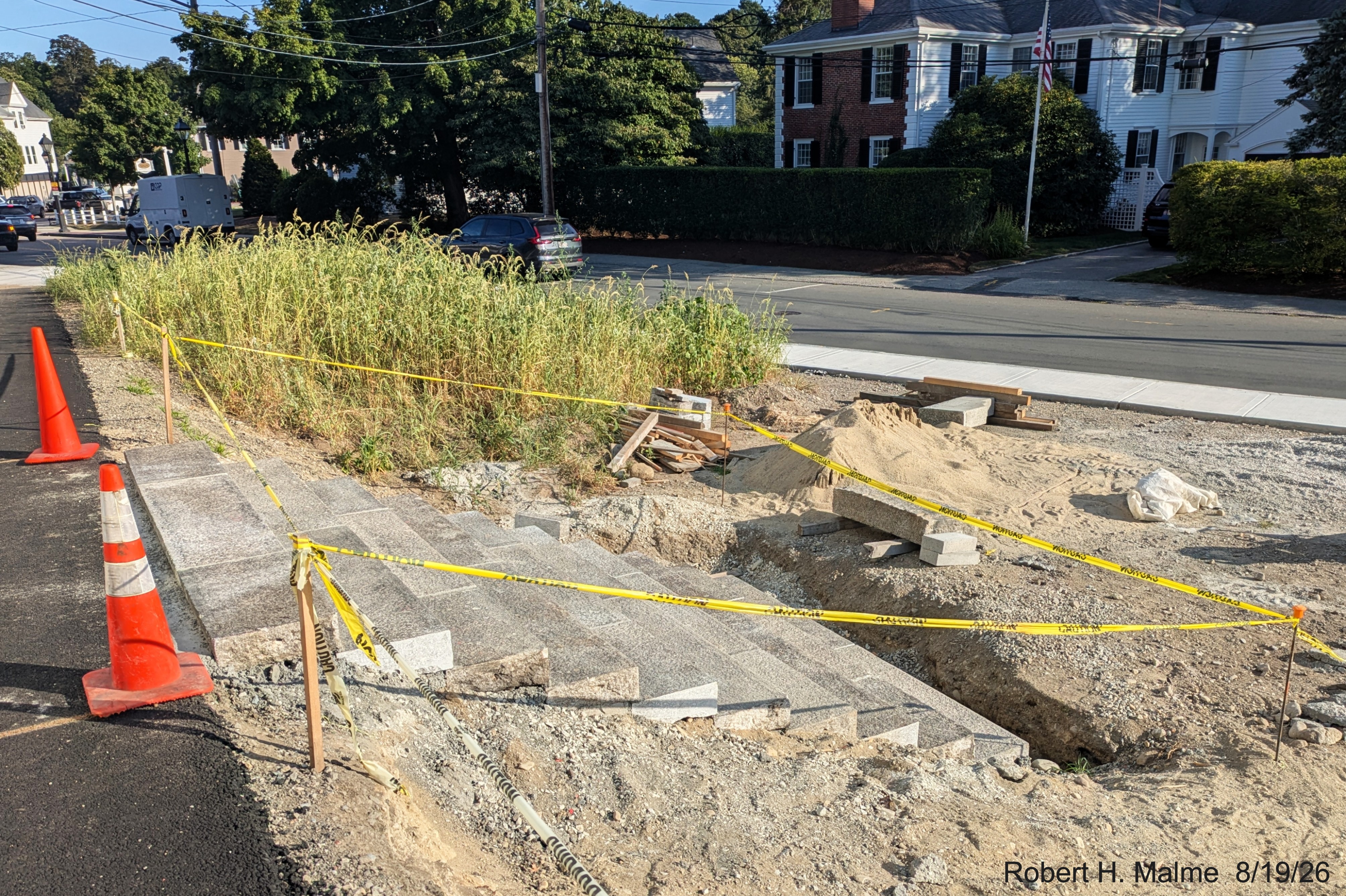 Image taken looking along Lincoln Street at pedestrian crossing with overgrown grasses
	now surrounding sidewalk across from the Benjamin Lincoln House, August 2026