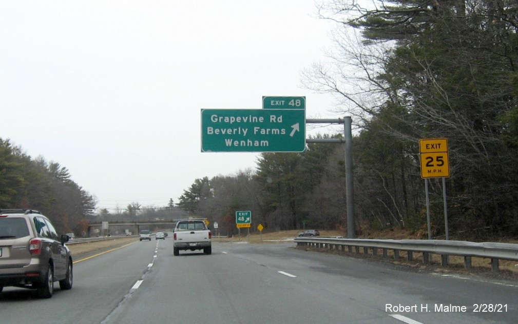 Image of overhead ramp sign for Grapevine Road exit with new milepost based exit number and yellow old exit number sign on support post on MA 128 North in Wenham, February 2021