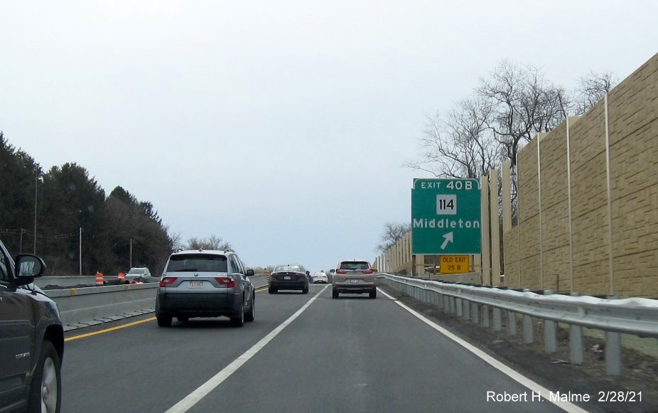 Image of ground mounted 1/4 mile advance sign for MA 114 West exit with new milepost based exit number 
                                             and yellow old exit number tab on left support post on MA 128 South in Peabody, February 2021
