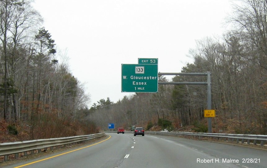 Image of 1 mile advance overhead sign for MA 133 exit with new milepost based exit number and yellow old exit number sign on support post on MA 128 North in Gloucester, February 2021