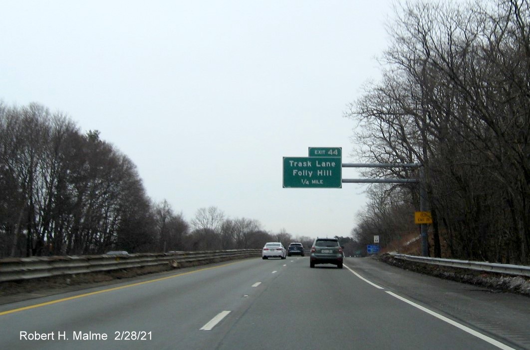 Image of 1/2 mile advance sign for Trask Lane exit with new milepost based exit number and yellow old exit number sign on support post on MA 128 North in Beverly, February 2021