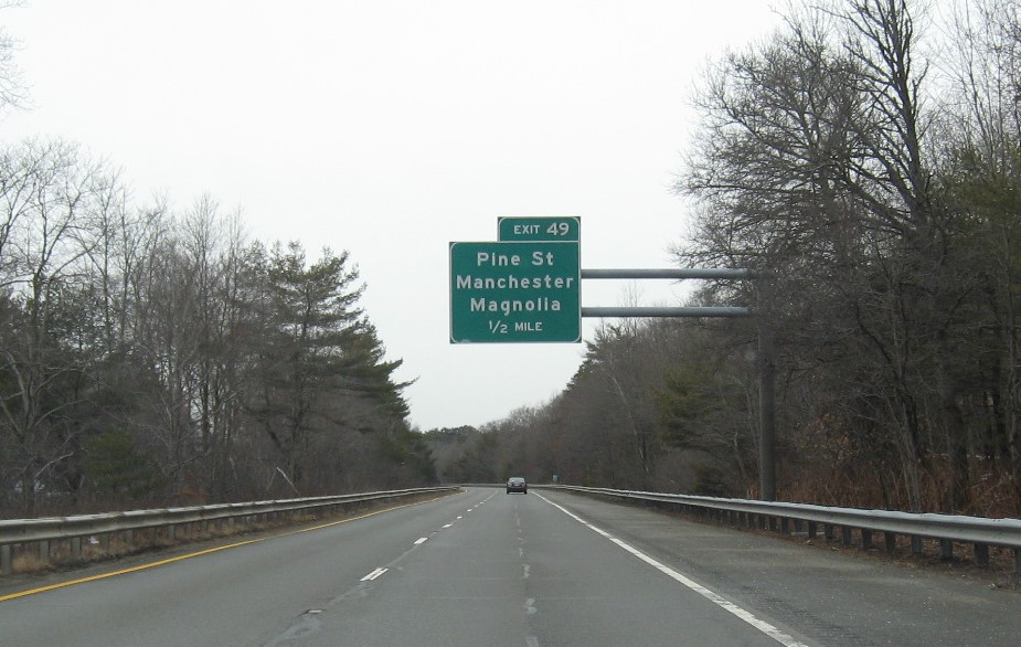 Image of 1/2 mile advance overhead sign for Pine Street exit with new milepost based exit number on MA 128 South in Manchester-by-the-Sea, February 2021