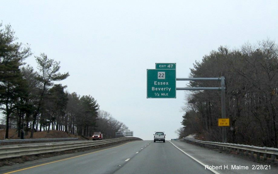 Image of 1/2 mile advance sign for MA 22 exit with new milepost based exit number and yellow old exit number sign on support post on MA 128 North in Beverly, February 2021