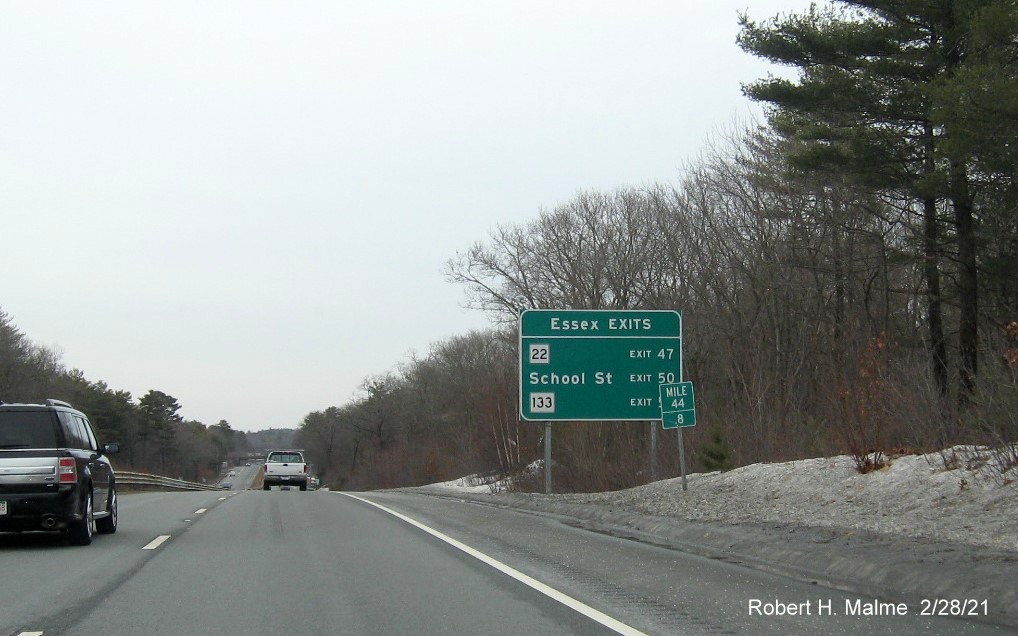 Image of ground mounted guide sign for Essex exit with new milepost based exit numbers on MA 128 North in Beverly, February 2021