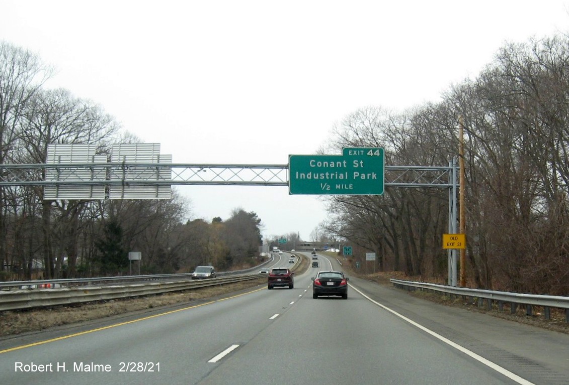 Image of 1/2 mile advance sign for Industrial Lane exit with new milepost based exit number and yellow old exit number sign on support post on MA 128 North in Beverly, February 2021