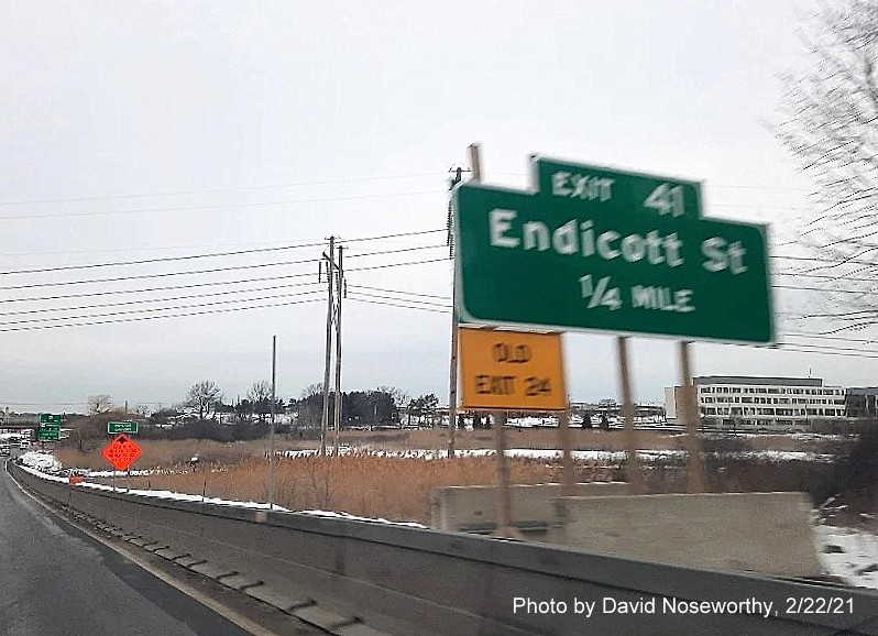 Image of ground mounted 1/2 mile advance sign for the Endicott Street exit with new milepost 
      based exit number and yellow old exit sign on the right support post on MA 128 North in Danvers, photo by David Noseworthy, February 2021