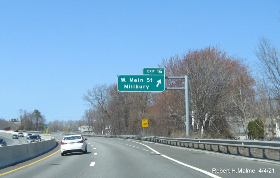 Image of overhead advance sign for West Main Street exit with new milepost based exit number and yellow Old Exit 8 advisory sign on left support on MA 146 North in Millbury, April 2021