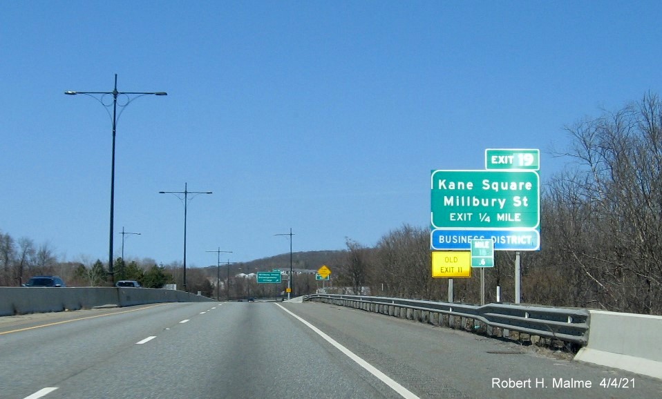 Image of 1/2 Mile advance ground mounted sign for Millbury Street exit with new milepost based exit number and yellow Old Exit 11 advisory sign on left support on MA 146 North in Worcester, April 2021