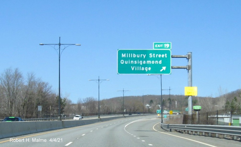 Image of overhead ramp sign for Millbury Street exit with new milepost based exit number and yellow Old Exit 11 advisory sign on support on MA 146 North in Worcester, April 2021