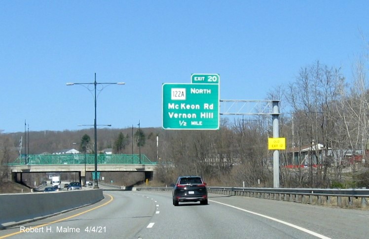 Image of 1/2 Mile advance overhead sign for MA 122A North exit with new milepost based exit number and yellow Old Exit 12 advisory sign on support on MA 146 North in Worcester, April 2021