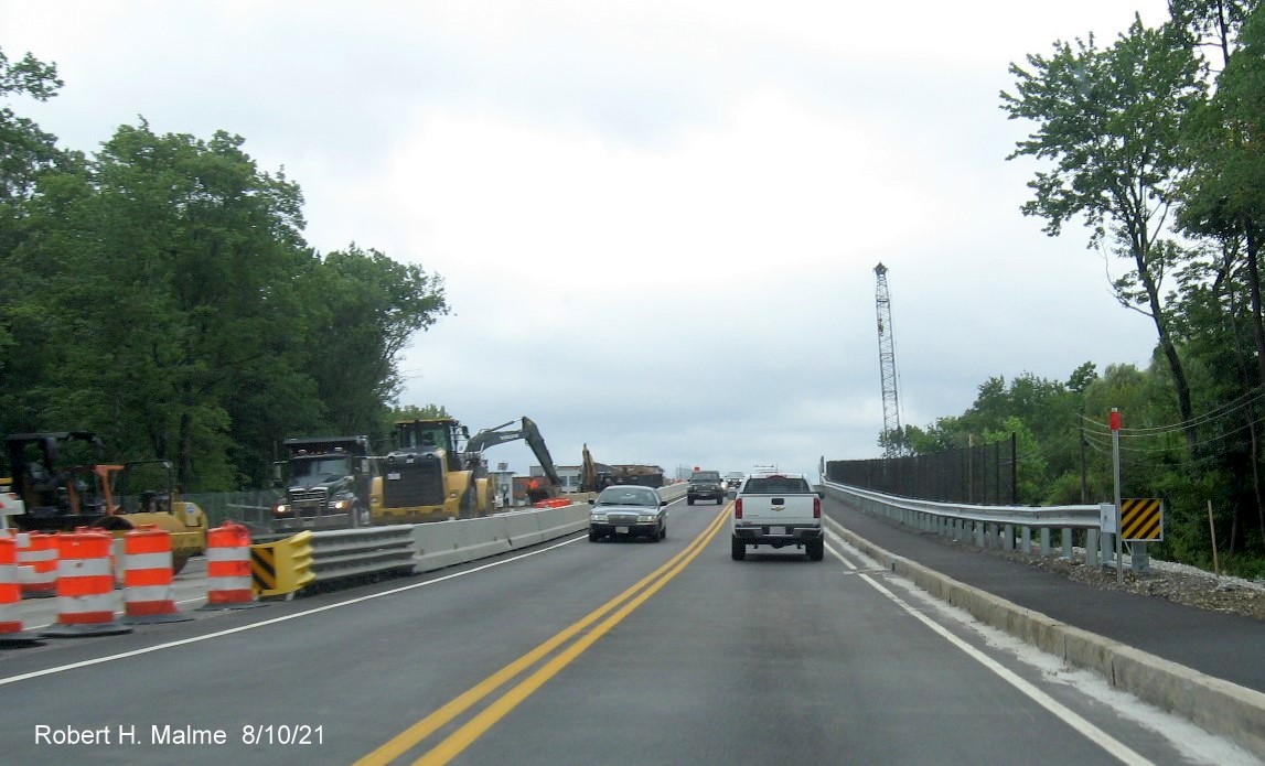 Image of traffic on MA 18 South at bottom of commuter railroad bridge still under construction in South 
     Weymouth, August 2021
