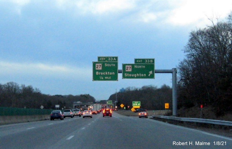 Image of overhead signs for MA 27 exits at ramp to MA 27 North with new milepost based exit number 
                                      and gore sign with yellow old exit number sign below on MA 24 South in Brockton, January 2021