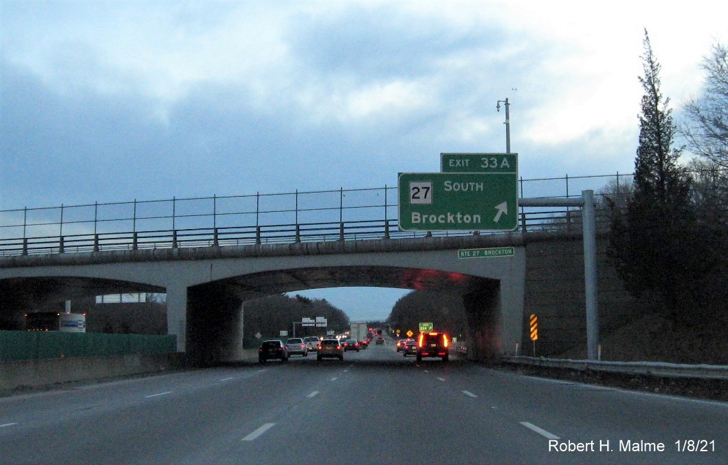 Image of overhead ramp sign for MA 27 South exit with new milepost based exit number 
                                      and gore sign with yellow old exit number sign below on MA 24 South in Brockton, January 2021
