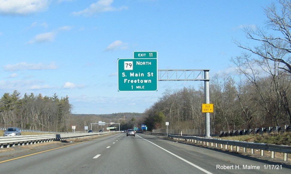 Image of 1-Mile advance overhead sign for MA 79 North exit with new milepost based exit number and yellow Old Exit 9 sign on support post on MA 24 North in Freetown, January 2021
