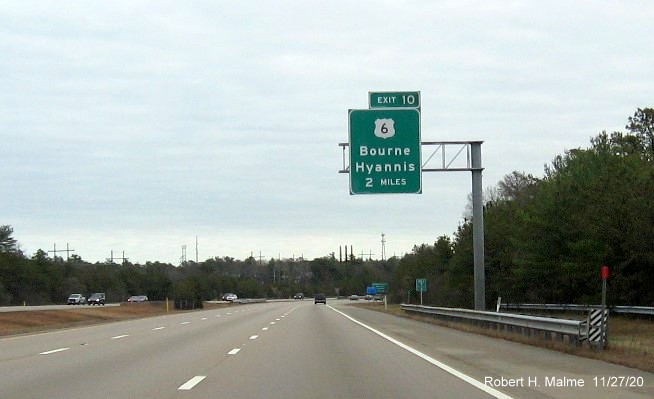 Image of 2-miles advance overhead sign for US 6 exit with new milepost based exit number on MA 25 East in Bourne, November 2020