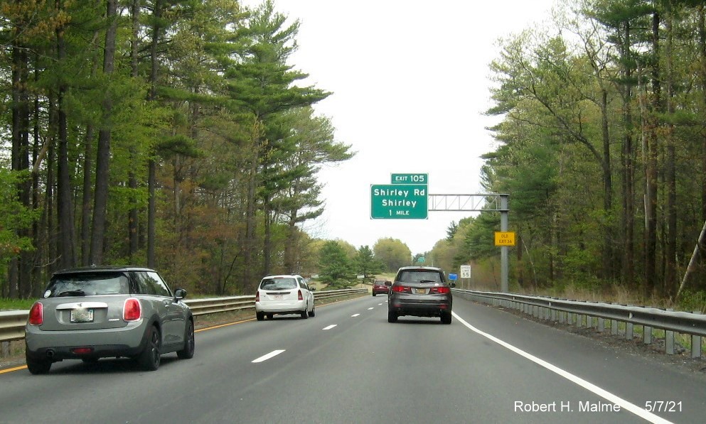 Image of 1 mile advance overhead sign for Shirley Road exit with new milepost based exit number and yellow Old Exit 36 advisory sign on support on MA 2 East on Shirley, May 2021