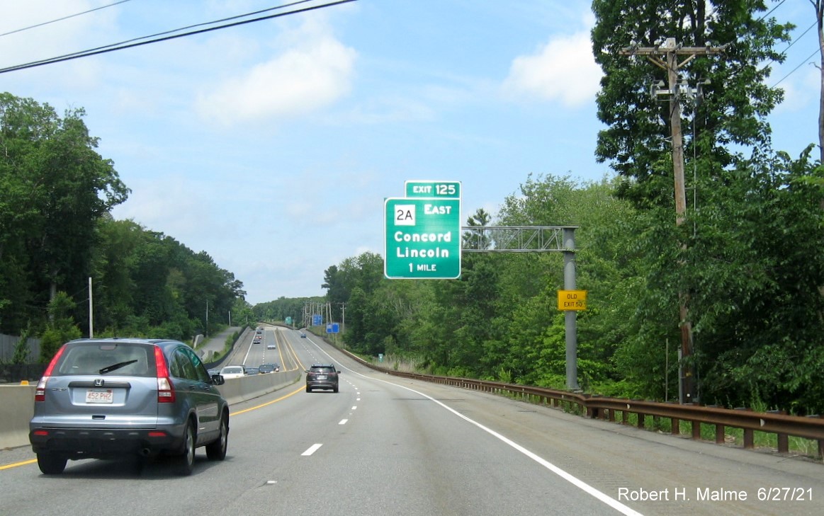 Image of 1 mile advance overhead sign for MA 2A East exit with new milepost based exit number and yellow Old Exit 50 advisory sign on support on MA 2 West in Lincoln, June 2021