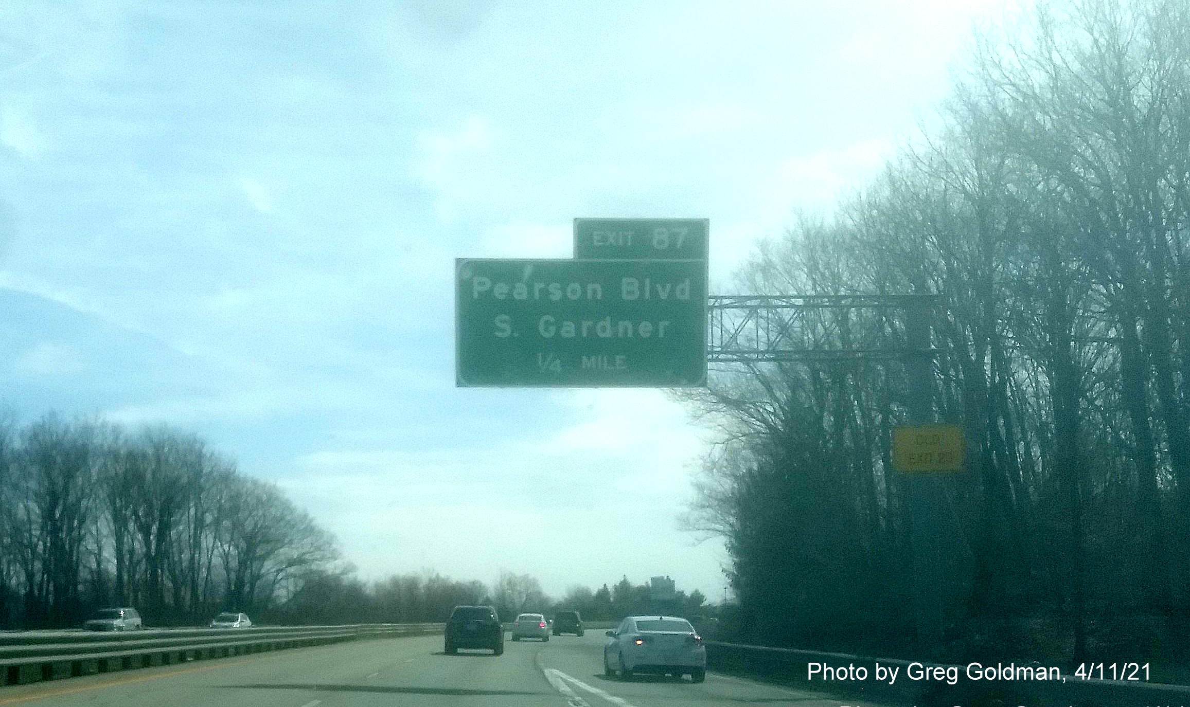 Image of 1/2 mile advance overhead sign for Pearson Blvd with new milepost based exit number and yellow Old Exit 23 advisory sign on support on MA 2 East in Gardner, by Greg Goldman, April 2021