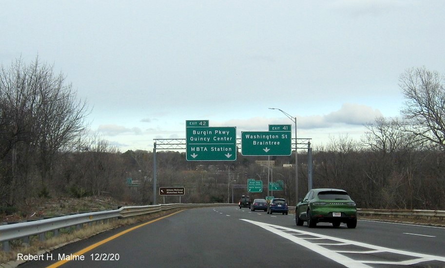Image of overhead signs on ramp from MA 3 South to Burgin Parkway/Washington Street exits with new milepost exit 
    numbers in Braintree, December 2020