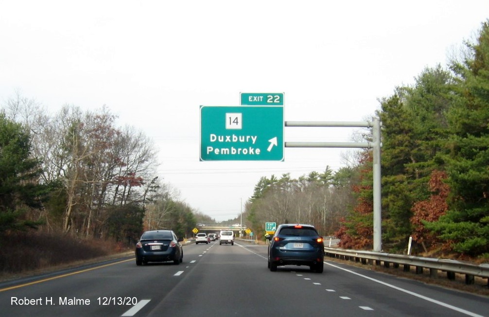 Image of overhead ramp sign for MA 14 exit with new milepost based exit number and gore sign with yellow old exit number tab below on MA 3 North in Duxbury, December 2020