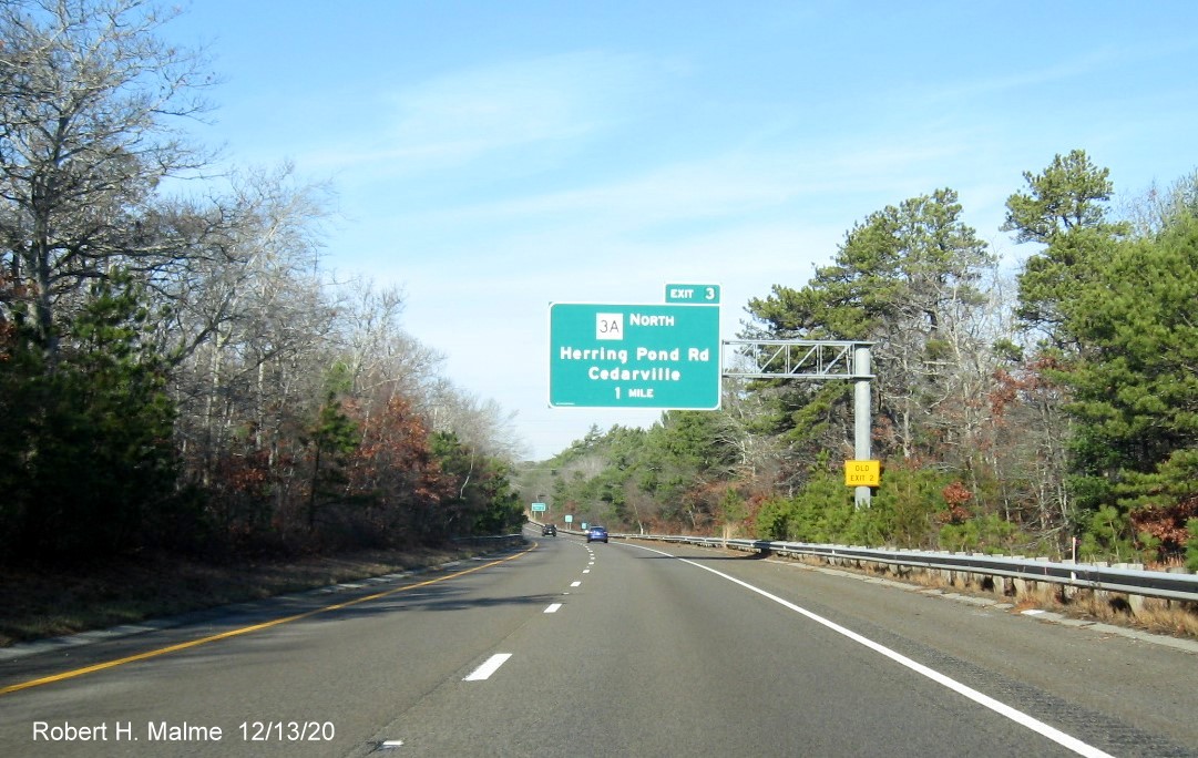 Image of 1-mile advance overhead sign for MA 3A North exit with new milepost based exit number and yellow old exit number tab on support on MA 3 North in Plymouth