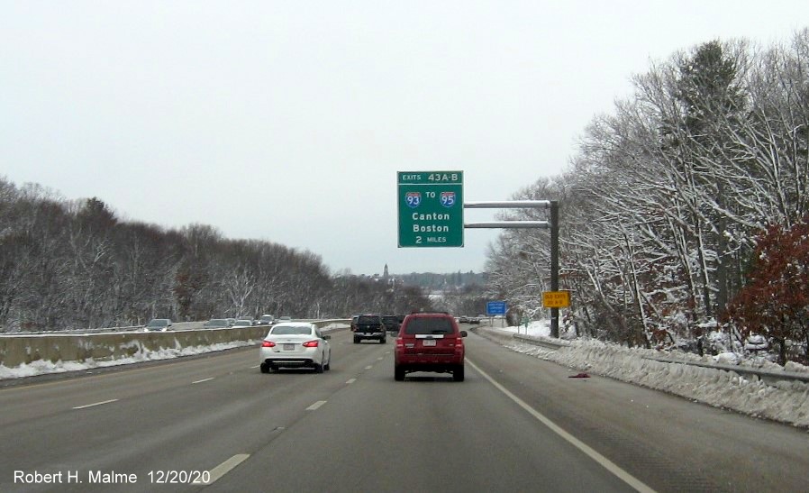 Image of 2 miles advance overhead sign for I-93 exits with new milepost based exit numbers and yellow old exit number tab on support on MA 3 North in Braintree, December 2020