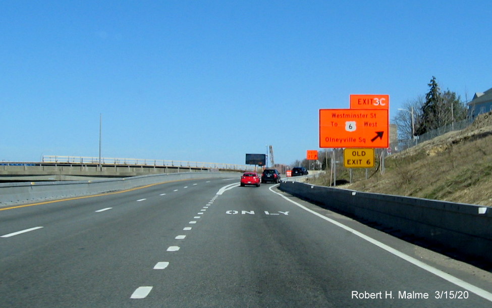 Image of orange temporary exit sign for the Westminster Avenue exit, used also for US 6 West during interchange construction project in Providence with new exit number and old exit number sign below, taken in March 2020