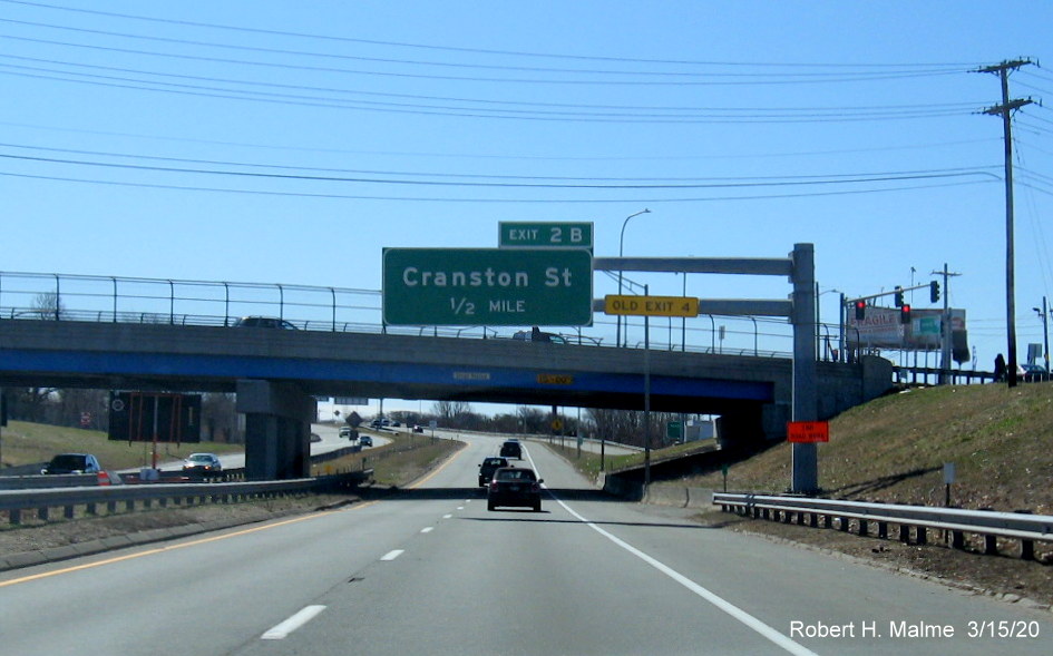 Image of overhead 1/2 mile advance for the Cranston Street exit on RI 10 South in Providence, with new exit number and old exit tab mounted on cantilever support, taken in March 2020