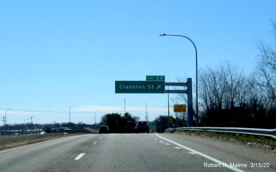Image of overhead ramp sign for Cranston Street exit on RI 10 South in Providence with new exit number and old exit number sign posted below, taken in March 2020