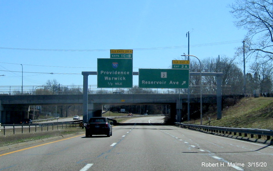 Image of overhead signage at ramp to RI 2 on RI 10 South in Providence, with new exit numbers and old exit number tabs, taken March 2020
