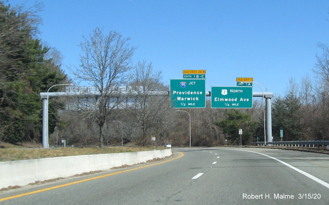 Image of overhead signs on RI 10 North for US 1 and I-95 exits with new exit numbers and old exit number tabs, taken March 2020