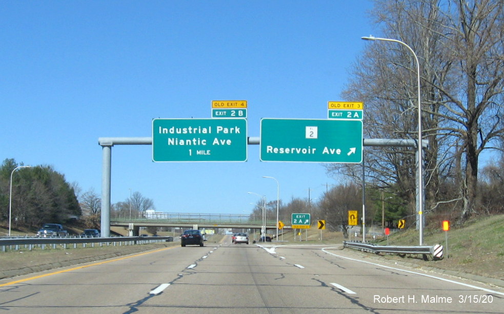 Image of overhead signage at ramp to RI 2 on RI 10 North in Providence with new exit numbers and old exit number tabs on top, taken in March 2020