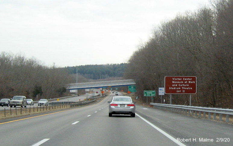 Image of recently placed brown attractions auxiliary sign with new milepost based exit number for RI 104 exit on RI 146 South in North Smithfield