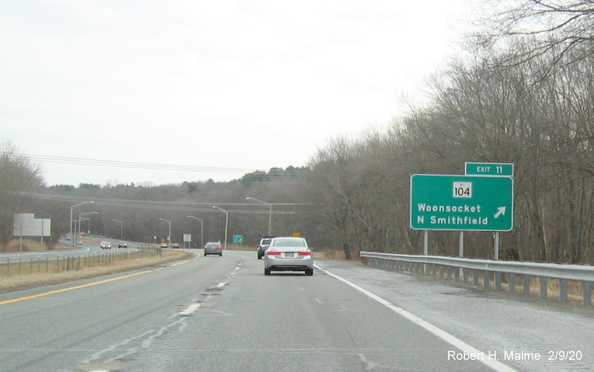 Image of ground mounted ramp sign with new milepost based exit number for RI 104 exit on RI 146 South in North Smithfield