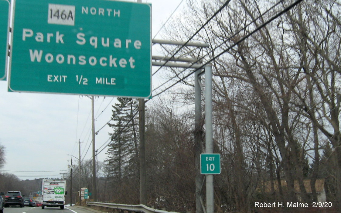 Image of recently placed milepost based exit number sign attached to existing overhead sign gantry for RI 146A exit on RI 146 North in Smithfield