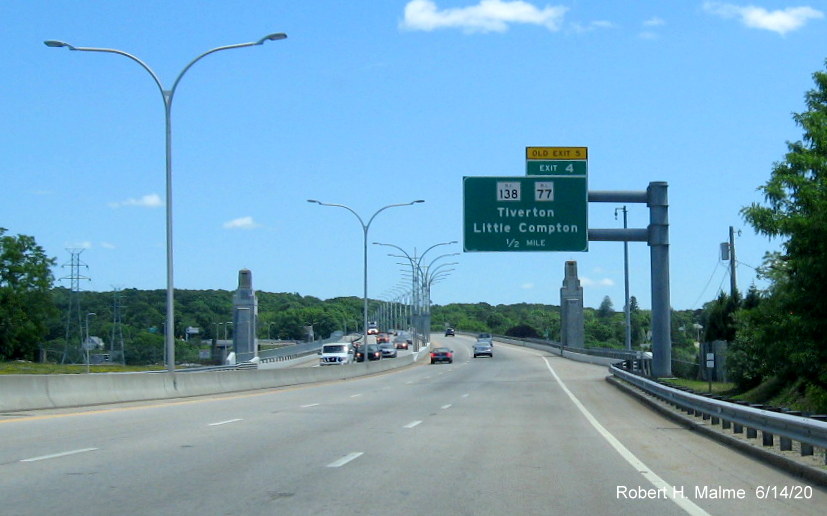 Image of existing overhead sign for RI 77/RI 138 exit with new exit number and yellow old exit number tab on RI 24 North in Portsmouth, taken June 2020
