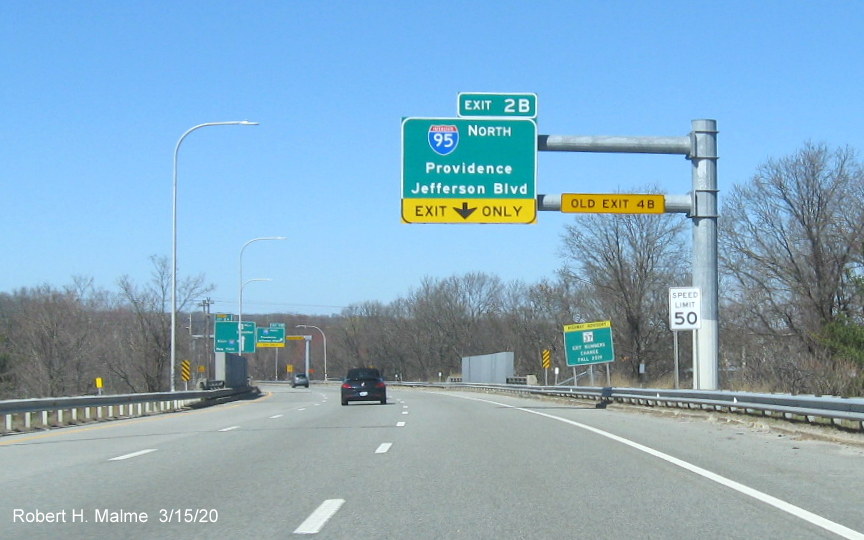 Image of overhead 1/4 mile advance exit only sign for I-95 North exit on RI 37 West in Cranston with new exit number and old exit number tab on bottom horizontal support beam, taken in March 2020