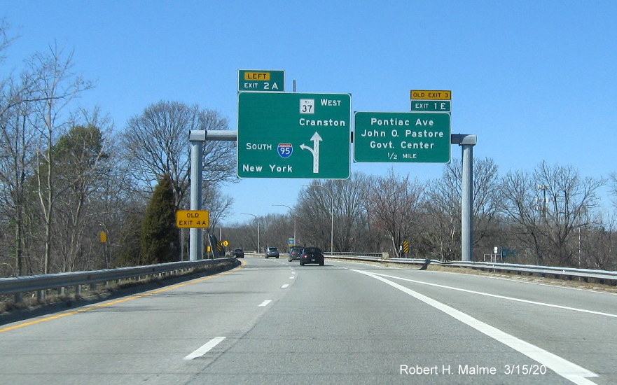 Image of overhead signage at ramp to I-95 South on RI 37 West in Cranston with new exit numbers and old exit number tabs, one on top of sign, taken in March 2020