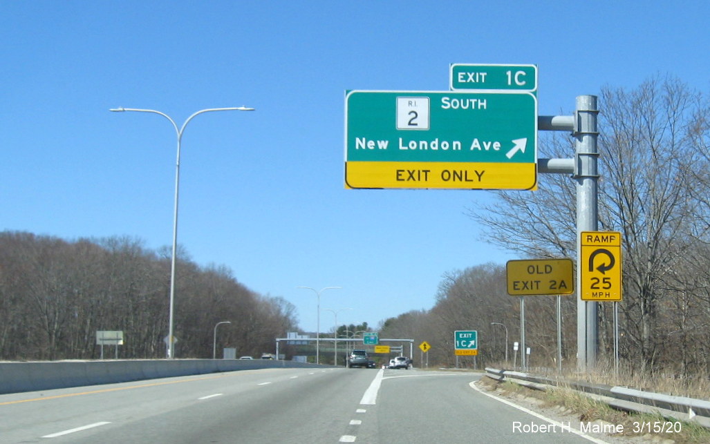 Image of overhead ramp sign for RI 2 South on RI 37 West in Cranston with new exit number and old exit number sign mounted to ground, taken in March 2020