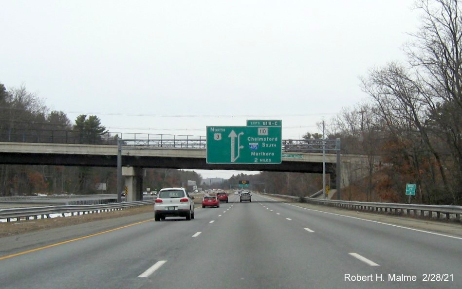 Image of 2 Miles advance overhead sign for I-495 South/MA 110 exits with new milepost based exit numbers on US 3 North in Chelmsford, February 2021