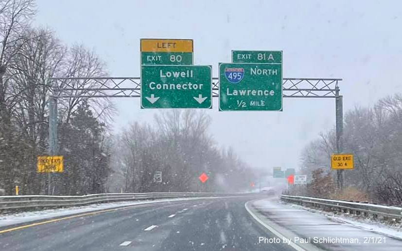 Image of advance overhead signs for I-495 North /Lowell Connector exits with new milepost based exit numbers and yellow old exit numbers signs on support posts on ramp from US 3 North in Chelmsford, by Paul Schlichtman. February 2021
