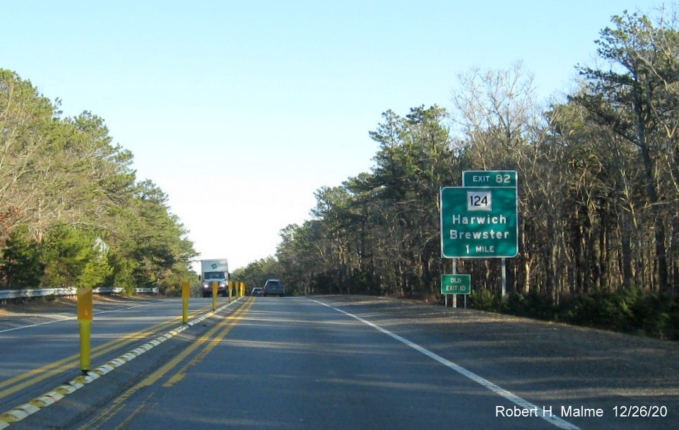 Image of 1-mile advance sign for MA 124 exit with new milepost based exit number and separate old exit number sign in front on US 6 East in Harwich, December 2020