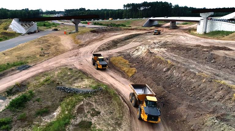 Image showing contruction trucks at site of future interchange between I-885/East End Connector and NC 147/Durham Freeway, by Durham Herald-Sun