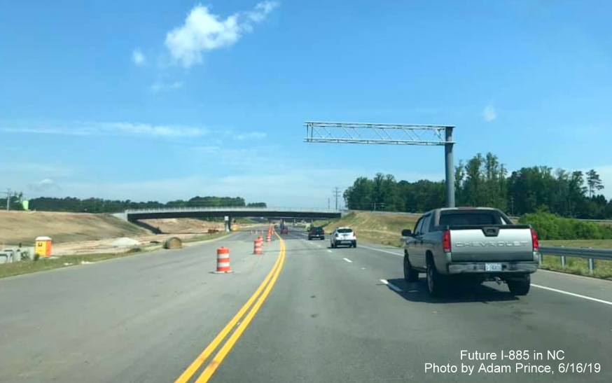 Image of overhead sign gantry over future I-885 Northbound lanes prior to Carr Road bridge on US 70 West in East End Connector Project work zone in Durham, by Adam Prince