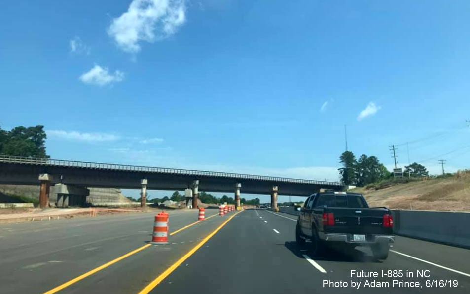 Image of traffic using future I-885 North lanes approaching temporary railroad bridge on US 70 West in East End Connector Project work zone in Durham by Adam Prince