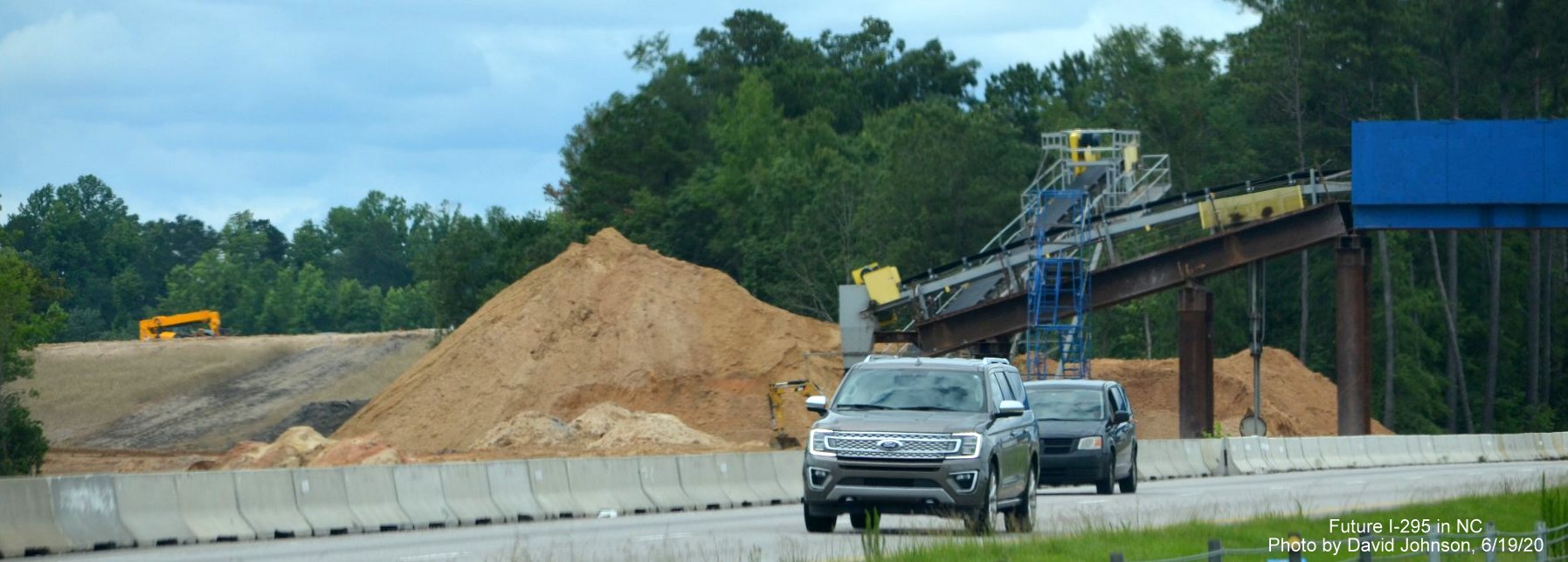 Image of dirt pile moved by conveyor belt across I-95 at future I-295 interchange near Hope Mills, by 
        David Johnson June 2020